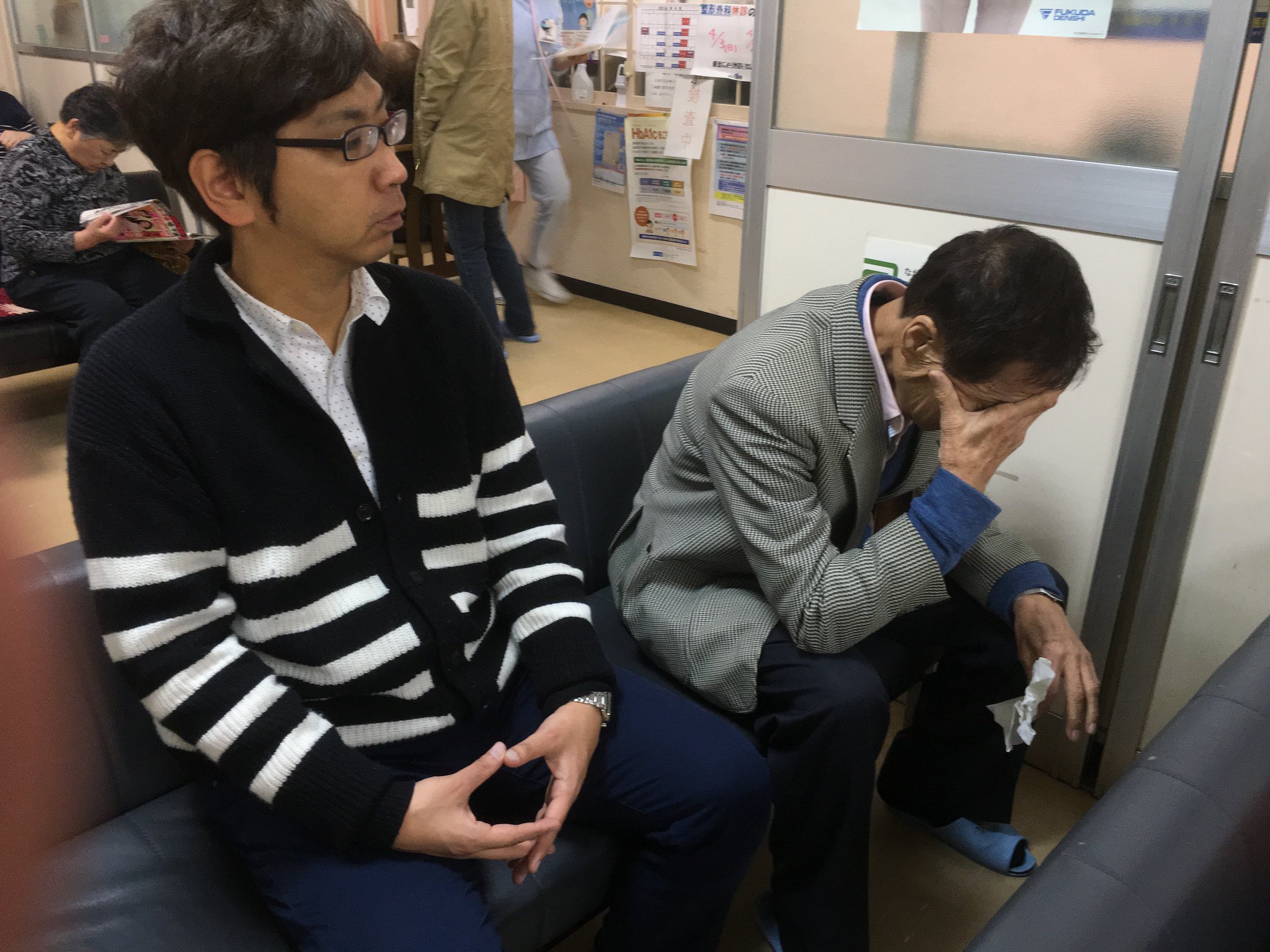病院へ到着。ＴはMr.ハタの隣に座り、一緒に順番を待つ。(1年前の英語版ツイートを元に再現しています) https://t.co/23ba1n38UK